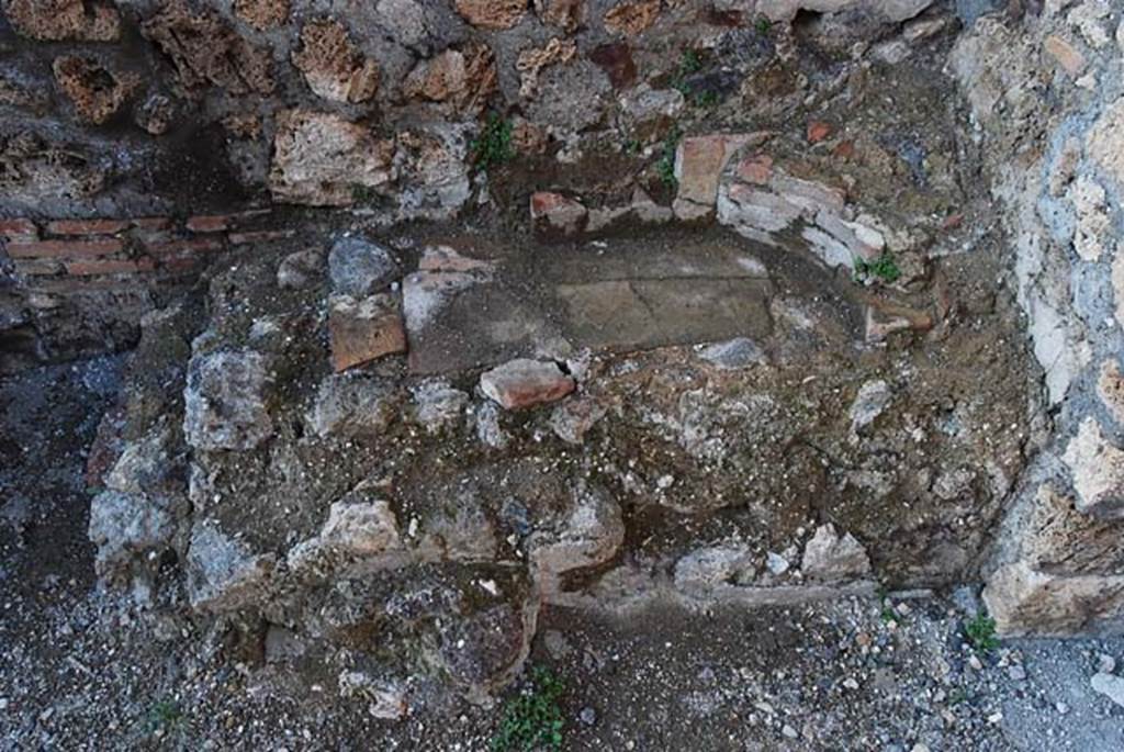 IX.3.10 Pompeii. May 2003. Detail of masonry remains on north side of doorway linking shop to bakery, possibly a small hearth.  Photo courtesy of Nicolas Monteix.
