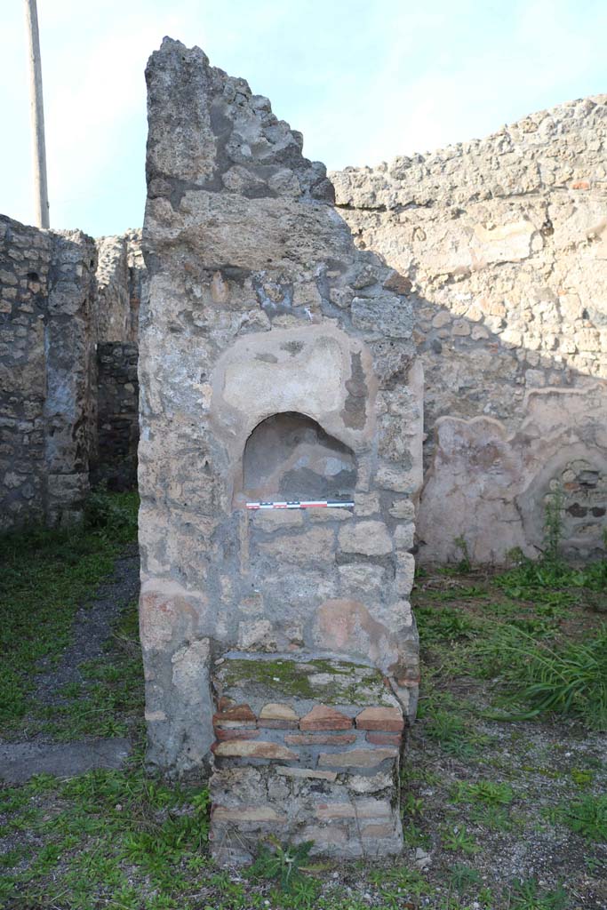 IX.3.14 Pompeii. December 2018. Detail of niche, and altar in shop. Photo courtesy of Aude Durand.
According to Boyce –
In the north wall is an arched niche (h.0.30, w.0.43, d.0.18, h. above floor 1.37), and against the wall below it stands a masonry altar (0.62 by 0.55. h.0.62).
See Boyce G. K., 1937. Corpus of the Lararia of Pompeii. Rome: MAAR 14. (p.84, no.413).