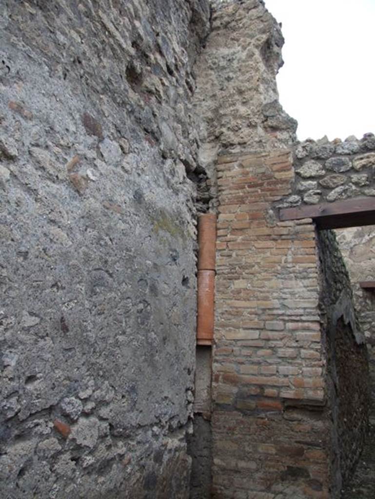 IX.3.17  Pompeii. March 2009. Downpipe on north wall of corridor.Remains of an upper storey latrine can just be seen above the downpipe. According to Hobson, he has identified six upper storey latrines in Reg. IX.
See Hobson, B., 2009. Latrinae et foricae: Toilets in the Roman World. London; Duckworth. (p. 75)
