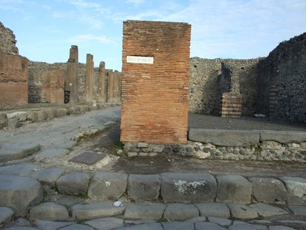 IX.4.1 shop on the corner of Via Stabia and Via Nola.  EX.K.QUI is cut into the pavement at white patch in bottom centre of picture.