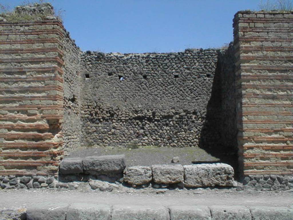 IX.4.3 Pompeii. May 2005. Entrance.
According to Maiuri, three of the shops on the corner of this insula, appear to have had an elevated threshold of at least 0.80m above the floor of the sidewalk and what should have been the original threshold. They clearly distinguish the brickwork/masonry of the above elevation from the original floor of the threshold. In the third taberna (from the corner of the quadrivium) IX.4.3, only one block of the threshold appears located in its place.
See Maiuri, A, (2002): L’ultima fase edilizia di Pompei, Arte Tipografica, Naples, (p.75, note 3).