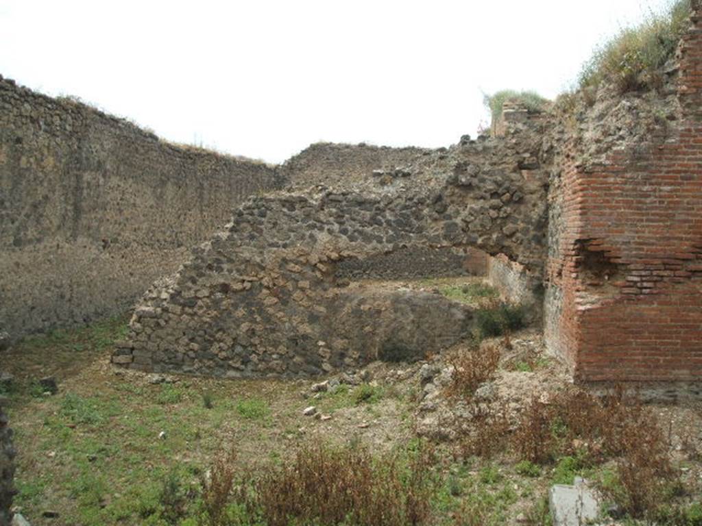 IX.4.15 Pompeii. May 2005. L shaped service area “t” with small garden. Looking west from entrance towards south-east corner of caldarium, and remains of garden wall. According to Jashemski, the five small windows of the caldarium looked out onto a small garden. The garden would have had a wall enclosing it, to hide from view the men walking back and forth tending the furnaces. The wall was only partially completed. See Jashemski, W. F., 1993. The Gardens of Pompeii, Volume II: Appendices. New York: Caratzas. (p.235).