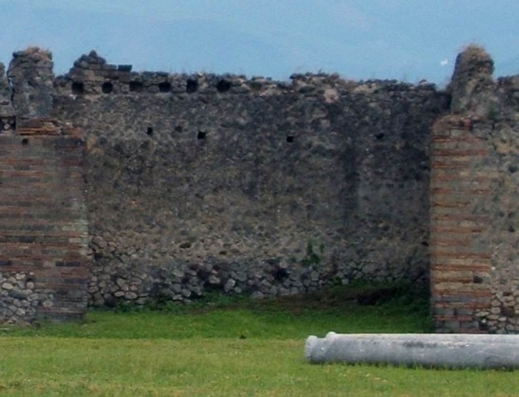 IX.4.18 Pompeii. May 2005. Recess in south side of baths behind IX.4.11-14.
Outside the wall at the left end of the photograph were the stairs at IX.4.14.
Note the support holes in the upper wall.
The entrance to room “f” is behind the brick wall on the left.
The wall of latrine “e” is on the right but there is no entrance here.
The latrine entrance is inside the entrance corridor at IX.4.10.