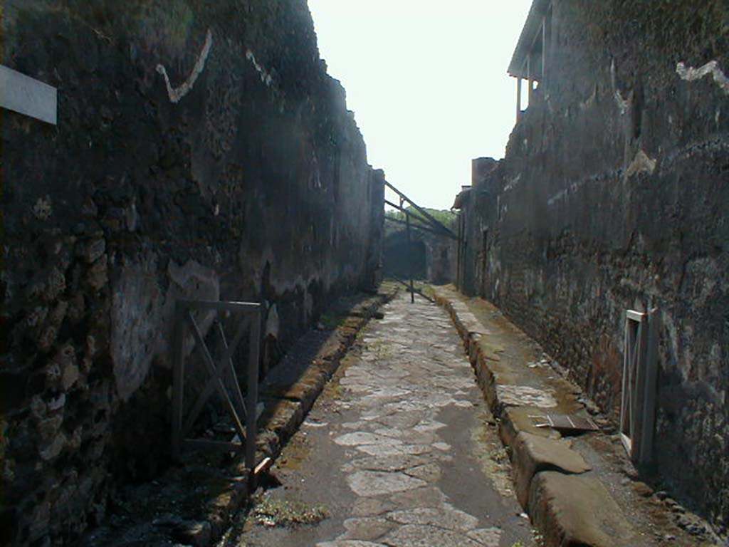 IX.8 Pompeii, on left. May 2005. Vicolo del Centenario, looking south. Side wall of IX.5.12, on right.