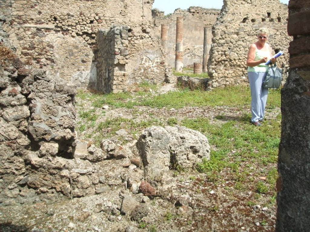 IX.6.3 Pompeii. May 2005. Looking north-east towards peristyle of IX.6.5 in distance. Side and rear walls are missing between IX.6.3 and IX.6.4, due to 1943 bombing. The lower left of the picture is the area of a small room on the north side of the atrium.