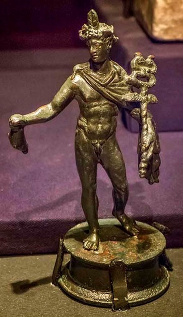 IX.6.5 Pompeii. May 2005. South-east corner of the south portico of the peristyle.
Bronze statuette of Mercury, holding his purse in his right hand, and caduceus in his left
