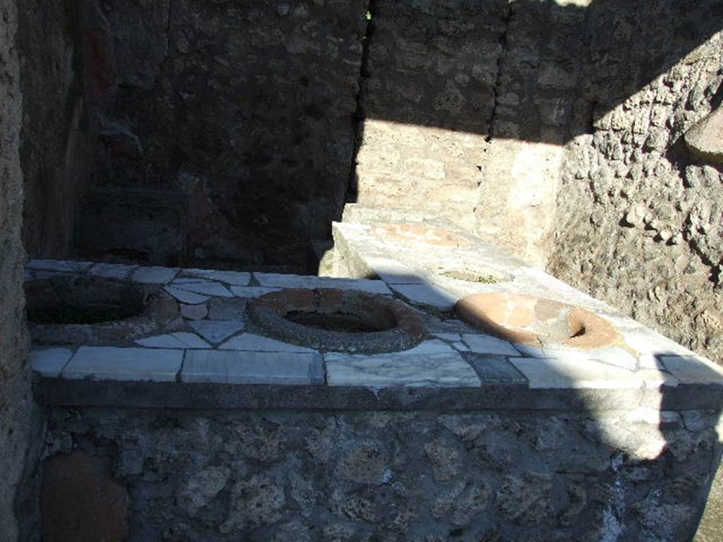 IX.7.13 Pompeii. December 2006. Counter with urns. In the rear wall is a blocked door that led to the rear.