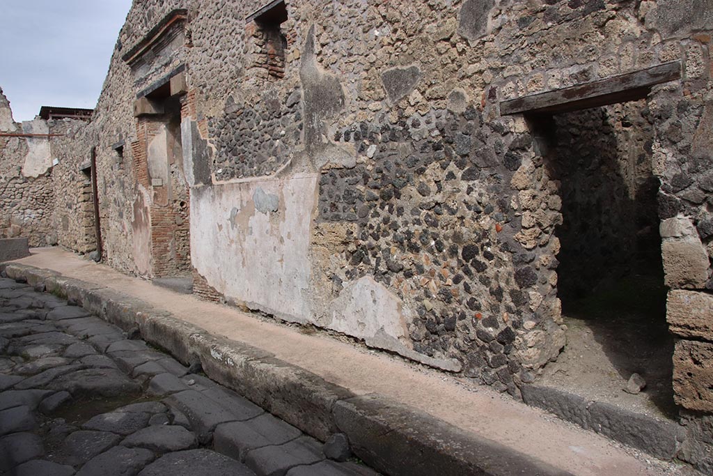 IX.7.15 Pompeii, on right. October 2024.
Entrance doorways on east side of Vicolo di Tesmo, with IX.7.16 in centre, and IX.7.17, on left. Photo courtesy of Klaus Heese.
