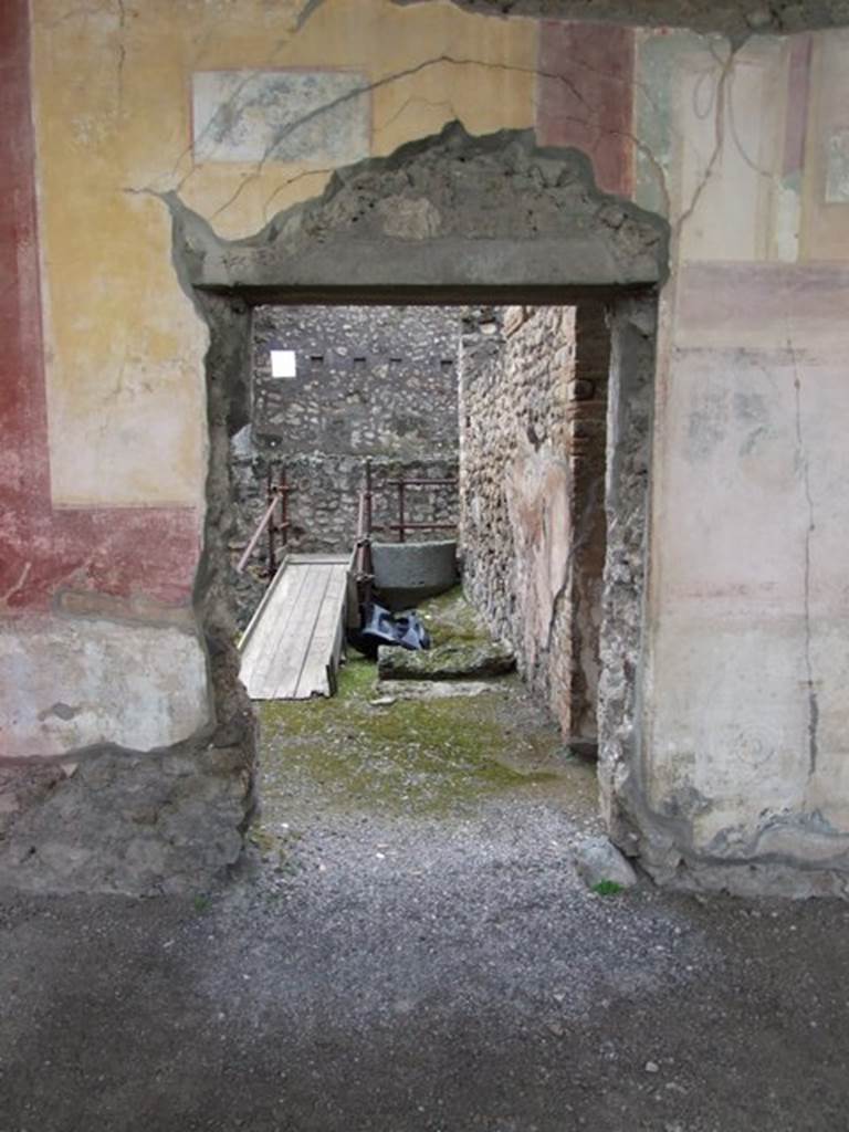 IX.8.6 Pompeii. March 2009. West portico, southern doorway in west wall leading to room 22. Against the north wall in room 22, are the remains of the lower stone step of the stairs to the upper floor, and an overturned lava stone.

