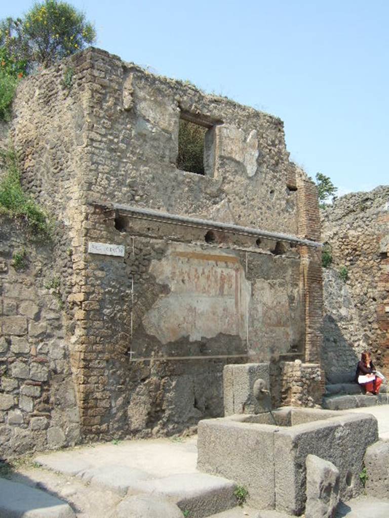 IX.11.1 Pompeii. May 2006. Front façade of house on west side of entrance doorway, with steps. House with street shrine and fountain outside.