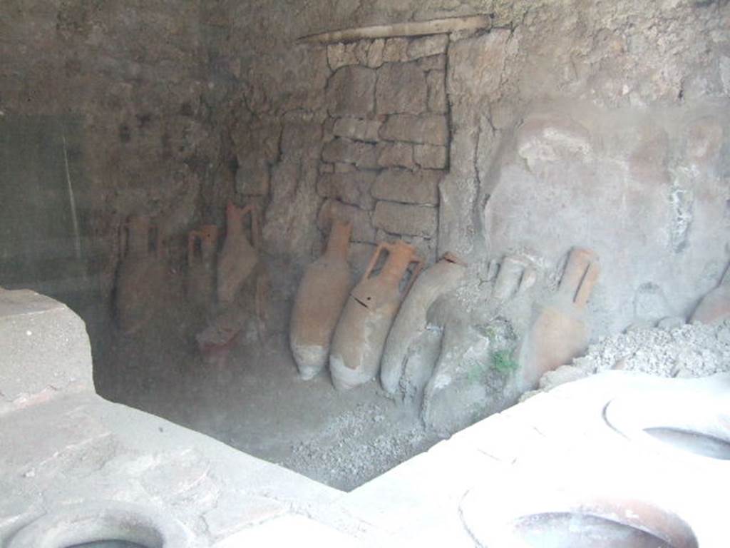 IX.11.2 Pompeii. May 2006. East wall with amphorae and a blocked doorway.