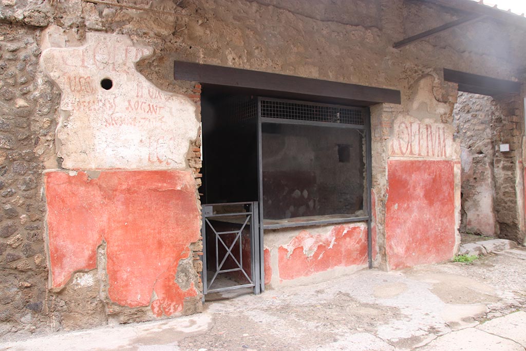 IX.11.2 Pompeii, in centre. October 2024. 
Entrance doorway with painted graffiti on both sides, with IX.11.3, on right. Photo courtesy of Klaus Heese
