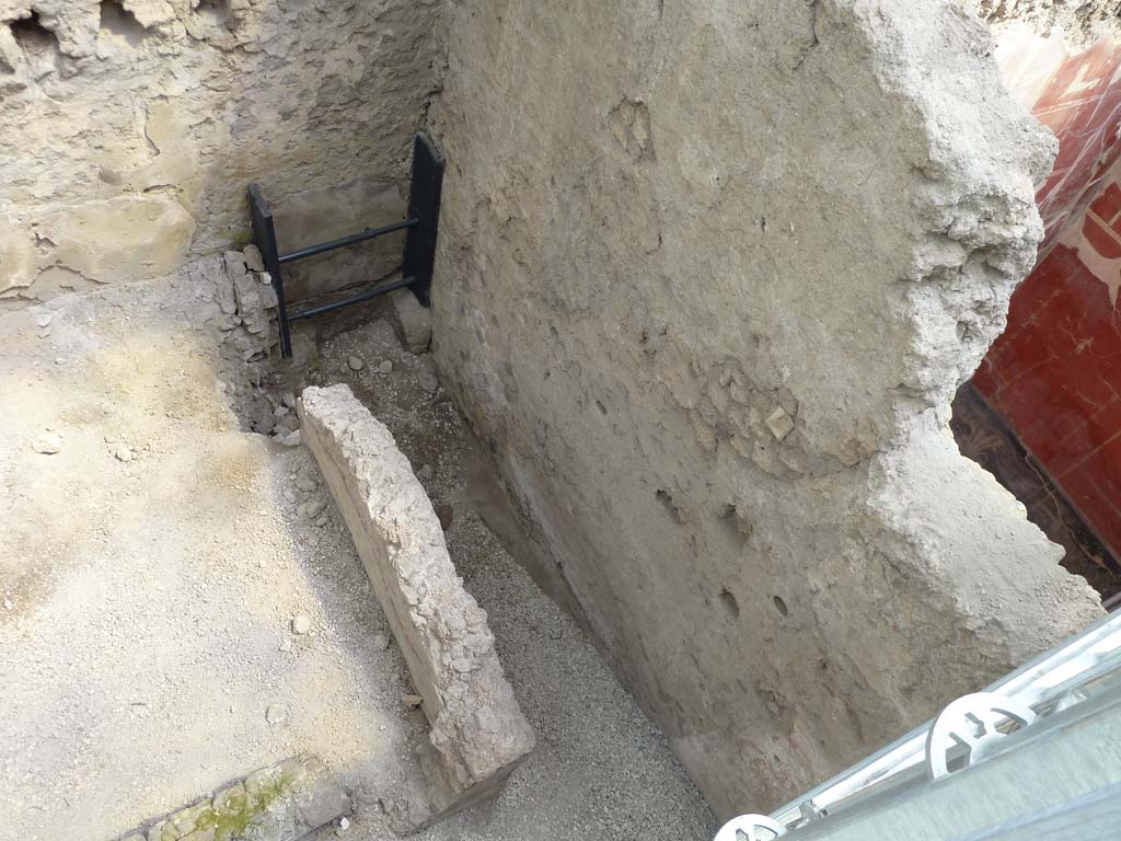 IX.12.B/IX.12.9 Pompeii. May 2010.
Room “a”, south end. Next to the room where the skeletons were found was a kitchen, with a stone counter on which a pile of lime for building purposes was found, and a long narrow room with a latrine, the contents of which flowed into a drain beneath the street. The backfill directly covers the pavement made up of five tiles with quarter-circle fins, arranged flat The tiles have a gradual slope from the kitchen counter, which occupies the south-west corner, towards the latrine drain on the street.
See PAP: New victims from Pompeii emerge from the excavation of the house of the chaste lovers
Stanza 13, lato sud. Accanto alla stanza in cui sono stati trovati gli scheletri c'era una cucina, con un bancone in muratura sulla sua superficie si trova infatti un mucchio di calce in polveri per la costruzione, e una stanza lunga e stretta con una latrina, il cui contenuto sarebbe defluito in un canale di scolo sotto la strada. Il terreno di riporto copre direttamente il lastricato composto da cinque tegole con aletta a quarto di cerchio, disposte di piatto. Le tegole hanno pendenza digradante dal banco della cucina, che occupa l’angolo sud-ovest, verso lo scolo della latrina sulla strada.
Vedi PAP: Pompei due scheletri rinvenuti sotto un crollo di muro