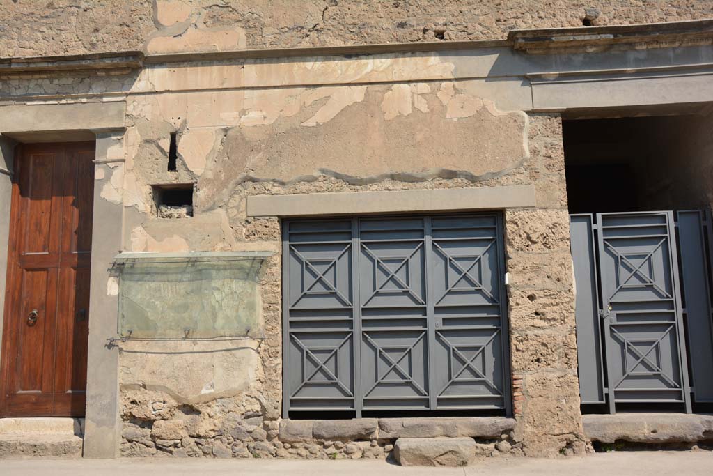 IX.13.1 Pompeii, on left, IX.13.2, in centre, and IX.13.3, on right. July 2017.
Looking north to entrance doorways on Via dell’Abbondanza, with remaining graffiti on west (left) side of central doorway.  
Foto Annette Haug, ERC Grant 681269 DÉCOR.
