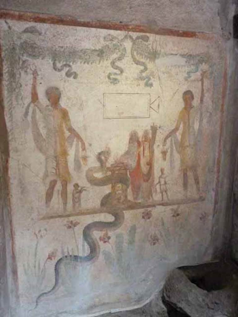 IX.13.1-3 Pompeii. May 2010.  Room 21. Household Lararium. 
Lararium by west wall of services atrium, near door to room 23, kitchen.
Two Lares, much taller than all the other figures, stand on either side. 
A Genius and a small Tibicen and a round altar are between them. 
By the round altar dressed in blue and red is Juno. 
A large snake winds round the altar.  See Fröhlich, T., 1991. Lararien und Fassadenbilder in den Vesuvstädten. Mainz: von Zabern. (L109).
