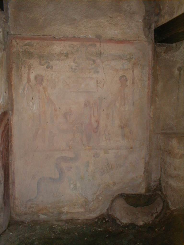 IX.13.1-3 Pompeii. September 2004. Room 21. 
Lararium by west wall of services atrium, near door to kitchen.
Two Lares, much taller than all the other figures, stand on either side. 
A Genius and a small Tibicen and a round altar are between them. 
By the round altar dressed in blue and red is Juno. 
A large snake winds round the altar.  See Fröhlich, T., 1991. Lararien und Fassadenbilder in den Vesuvstädten. Mainz: von Zabern. (L109).
