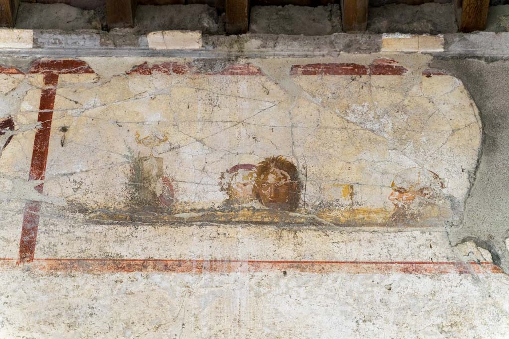 IX.13.3 Pompeii. October 2021.
Room 9, detail of panel on upper east wall with painting of masks or faces. Photo courtesy of Johannes Eber.