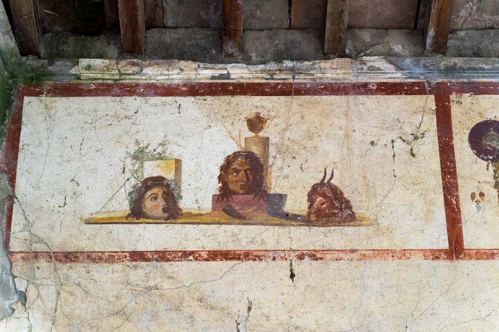 IX.13.3 Pompeii. October 2021.
Room 9, detail of panel with painting of masks or heads, from north end of east wall. Photo courtesy of Johannes Eber.