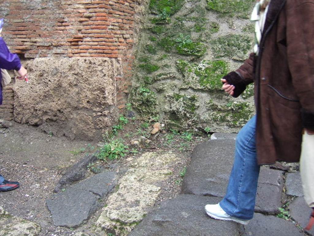 IX.13.6 Pompeii. December 2005. East corner of insula. On this corner used to stand an amphora with its top half removed (Amphora Urinaria). 
This was to receive the urine of passers by, for the use of the fullers or fullones. According to Della Corte, found immediately at the turn into the eastern vicolo at the corner of the insula, was a terracotta amphora.
This had been conserved in situ from the time of excavation, (the end of April 1913). It had been restored from broken pieces, but with a broken rim since antiquity.  This was an example of a (Urinarium) gastrum.
It would have been placed there by the fuller Fabius Ululitremulus, to collect the urine of passer's by for his industry’s use. The urine was used as a bleach as part of the cleaning process. See Della Corte, M., 1965.  Case ed Abitanti di Pompei. Napoli: Fausto Fiorentino. (p.338)
See amphora in situ in SAP photo C 753 (=D80935) taken about 1915, shown in  See Varone, A. and Stefani, G., 2009. Titulorum Pictorum Pompeianorum, Rome: L’erma di Bretschneider, (p.471)




