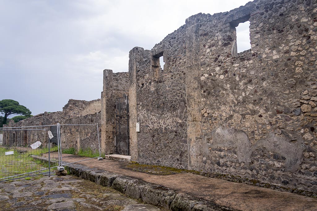 IX.14.4 Pompeii. July 2024. 
Looking east along front façade towards entrance doorway on south side of Via di Nola. Photo courtesy of Johannes Eber.

