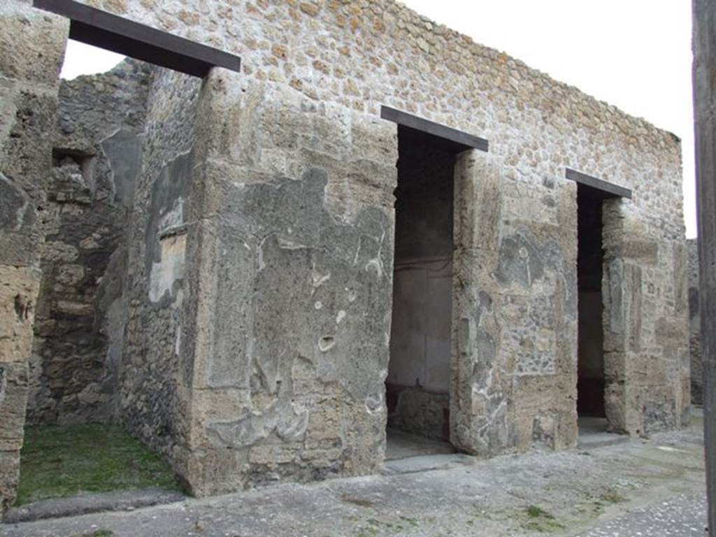 IX.14.4 Pompeii. December 2007. Three cubicula rooms C, E and F on the east side of the atrium. All of these doorways were found with their thresholds or sills made of lava. In the room on the left, the south wall still shows a small area of II style painted decoration. When found, the walls had large panels of painted imitation coloured marble, but the colour had faded. Each panel was surrounded by a yellow fascia, also of painted imitation marble.