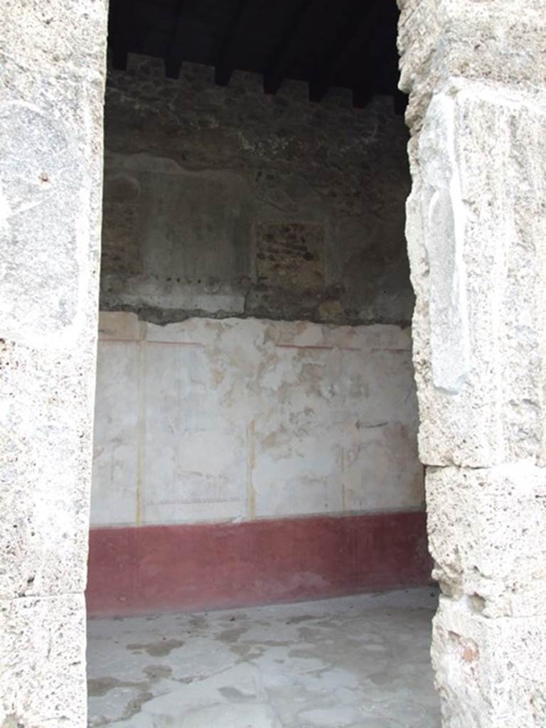 IX.14.4 Pompeii. December 2007. Doorway to room F cubiculum on the east side of the atrium. Looking towards east wall. This cubiculum also had walls divided into panels on a white background, with a red base. The painting in the centre of the panels had faded and disappeared.