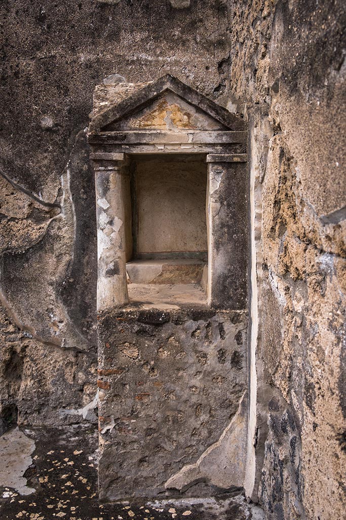 IX.14.4 Pompeii. July 2024.
Looking west in north-west corner of atrium towards lararium shrine 32.
Photo courtesy of Johannes Eber.