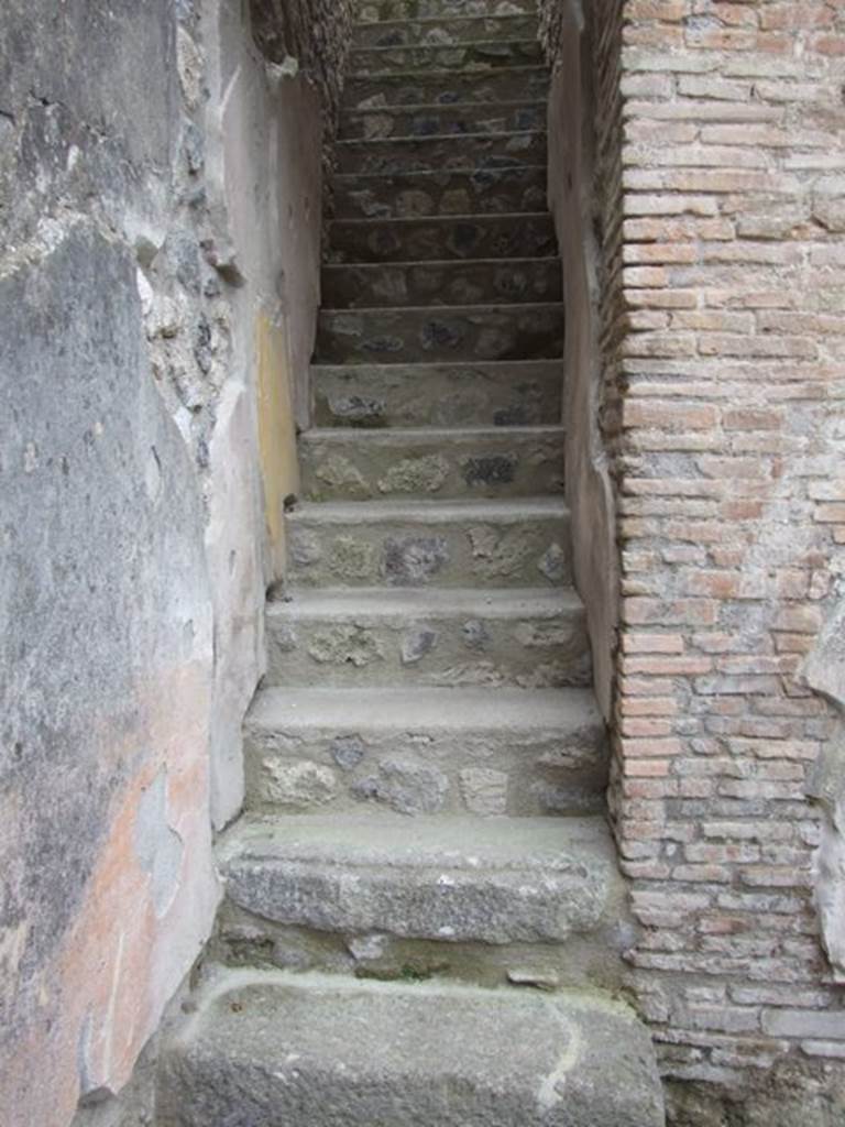 IX.14.4 Pompeii. December 2007. Staircase to upper floor in south-east corner of secondary atrium 27 at IX.14.2. According to NdS, the first three steps were of Vesuvian stone, above the last of which would have been a wooden door. The other steps were in masonry, and showed clearly the imprint of their antique facing of wood. The walls, according to the course of the stairs, were coated with plastered brick, lying above a coating of yellow plaster with which the walls had previously been covered. See Notizie degli Scavi, 1911, (p.268).