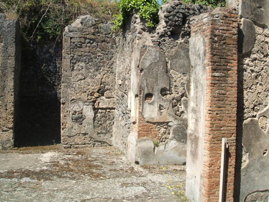 IX.14.4 Pompeii. May 2005. North-west corner of atrium 27. The narrow doorway to room 29 can be seen on the left, the wider entrance fauces 28 is centre right and the doorway to room 31 is right. Room 31 connected atrium 27 and atrium B.