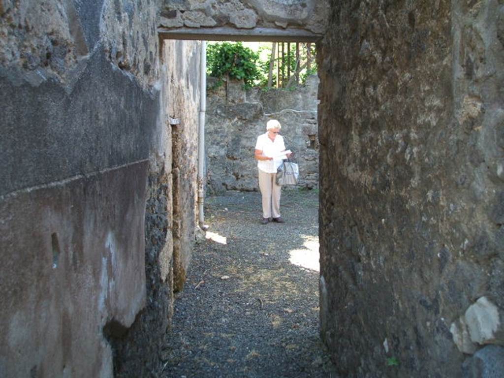 IX.14.4 Pompeii. May 2005. Looking south through corridor (r) to rustic area with doorway to room 6 on the left.
