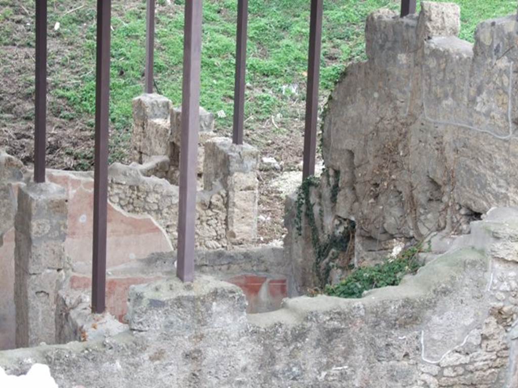 IX.14.c Pompeii. December 2007. Looking south across room 4, along the east inside of the front wall. Photographed from roof of IX.14.2/4. Nearest the camera behind the first wall would be room 4, with darker red plastered south wall. Behind room 4, would be room 1, the entrance corridor. Room 4 had a similar wall decoration to room 5, a low black plinth, red decorations and yellow frieze. Room 4 had a low flat ceiling, shown by the holes for the beams of the floor above, in the west wall. To the north of room 4 there were masonry stairs that led to the upper floor.