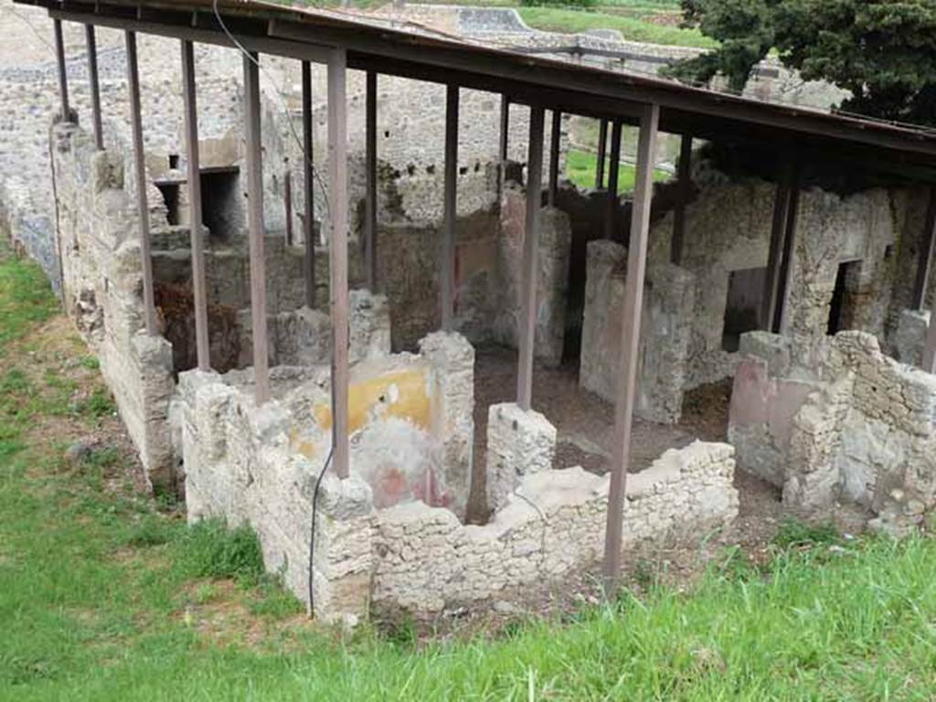 IX.14.c Pompeii. May 2010. Looking north-east. Room 7 is in the foreground with its doorway to the south side of the atrium. To the right of the doorway, front right in this picture, is one of the cupboards that flanked the entrance to room 8. According to NdS, at the sides of the entrance corridor were two rooms 4 and 5. The room with the north wall painted red and yellow is room 5. Room 5 had a similar wall decoration to room 4, which was a low black plinth, red decorations and yellow frieze. See Notizie degli Scavi di Antichità, 1911, p. 375.