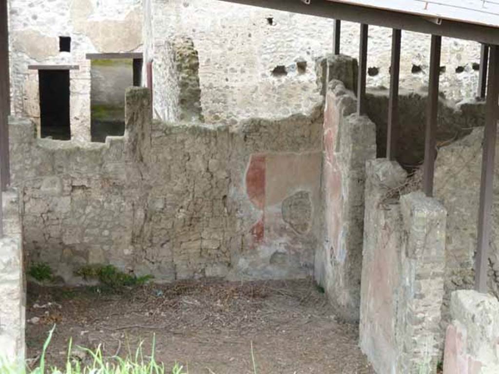 IX.14.c Pompeii. May 2010. North wall of atrium 2, with remains of painted decoration in north-east corner. To the right in the east wall of the atrium, centre right of picture, is the doorway to rectangular room 6. This was decorated with white plaster. It was covered with a low vaulted ceiling, parts of which remained visible in the east and west walls. The flooring was of opus signinum. In the south wall was a window overlooking the garden, 3. On the left of the picture, in the north-west corner of the atrium, was a masonry staircase to the upper floor.