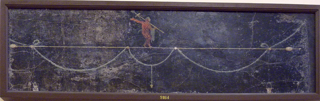 HGW06 Pompeii. Found in triclinium on 1st June 1748.
Wall painting of a Satyr with a thyrsus on his shoulder and who is walking on a horizontal thyrsus.
Now in Naples Archaeological Museum. Inventory number 9164.