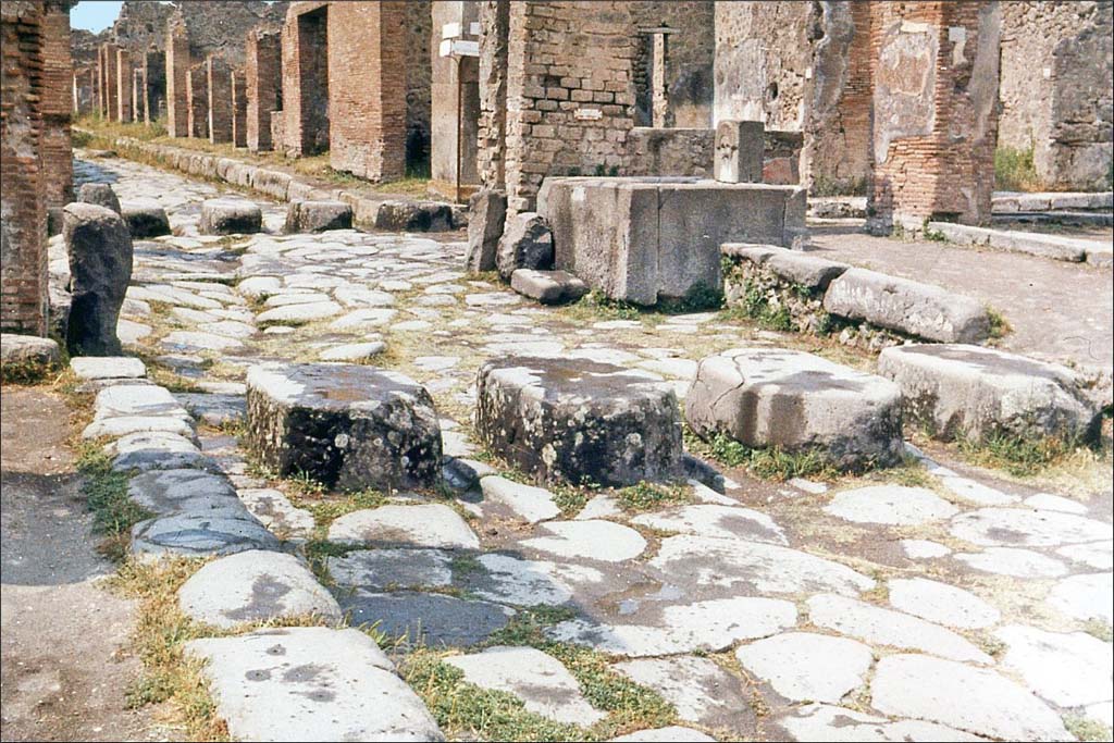 Via Stabiana, Pompeii. June 1962. Looking north-east at junction of Via Stabiana, with Via dell’Abbondanza.
Photo by Brian Philp: Pictorial Colour Slides, forwarded by Peter Woods
(P43.16 POMPEII PEDESTRIAN ROAD CROSSINGS AND FOUNTAIN).