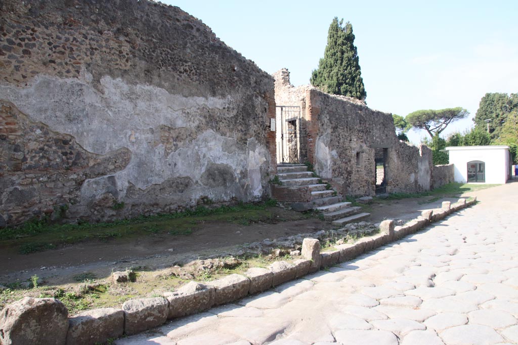 Via dei Sepolcri, west side at north end, Pompeii. October 2023. 
Looking north along exterior façade towards entrance doorway of Villa of Diomedes, followed by doorway into HGW25, part of Villa. 
Photo courtesy of Klaus Heese.
