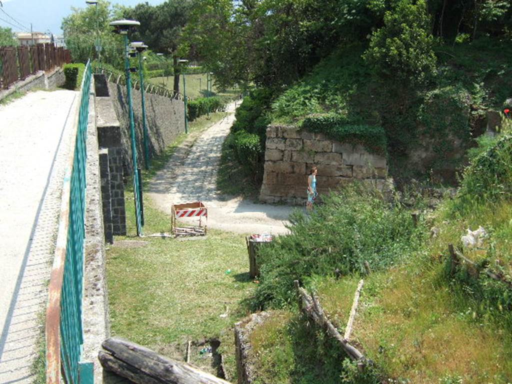 Via dell’Abbondanza. May 2006. Looking south along the city walls at the junction with the Sarno Gate. 
The structure on the left is the modern railway and foot bridge which blocks the ancient route of the Via dell’Abbondanza.
