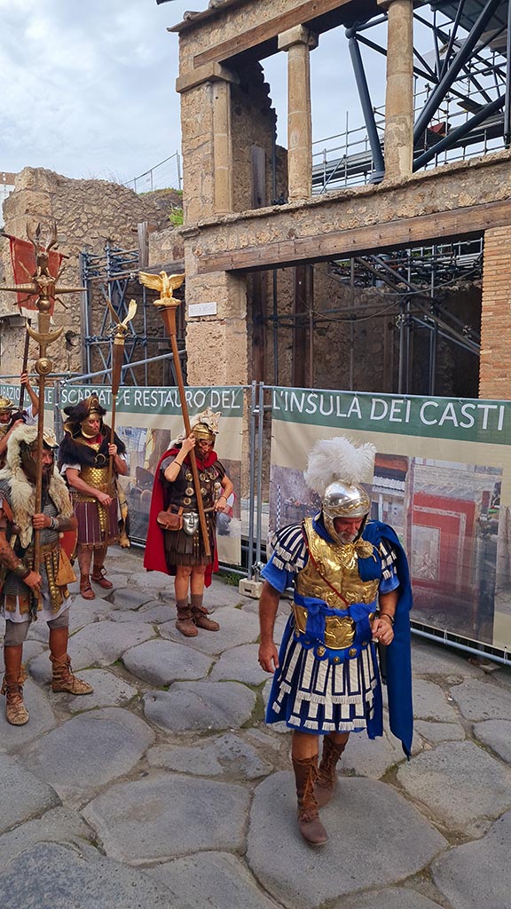 Via dell’Abbondanza, north side. 28th September 2024. 
Looking towards unnamed vicolo between IX.11 and IX.12, and IX.12.1.
A recreation of the uniform of the Classis Misenensis, during “Ludi Pompeiani” event. 
Photo courtesy of Giuseppe Ciaramella.


