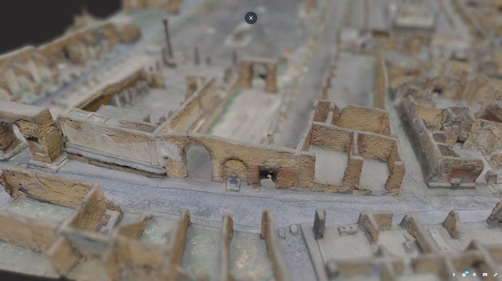 Vicolo dei Soprastanti, Pompeii. March 2019. Detail from model in Naples Archaeological Museum.
Looking towards south side of Vicolo dei Soprastanti.
On the left is the Arch in the north-east corner of the Forum, next to the rear of the Temple of Jupiter, then the arched entrance to Forum at VII.7.26, a fountain, VII.7.25 and 24, and small alley/roadway leading to VII.7.23, on right.
Foto Taylor Lauritsen, ERC Grant 681269 DÉCOR