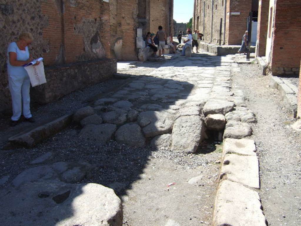 Via degli Augustali between VII.9 and VII.4. September 2005. Looking west towards junction with Via del Foro (on right) and Vicolo dei Soprastanti (ahead). On the north side of the street appears to be a drain.