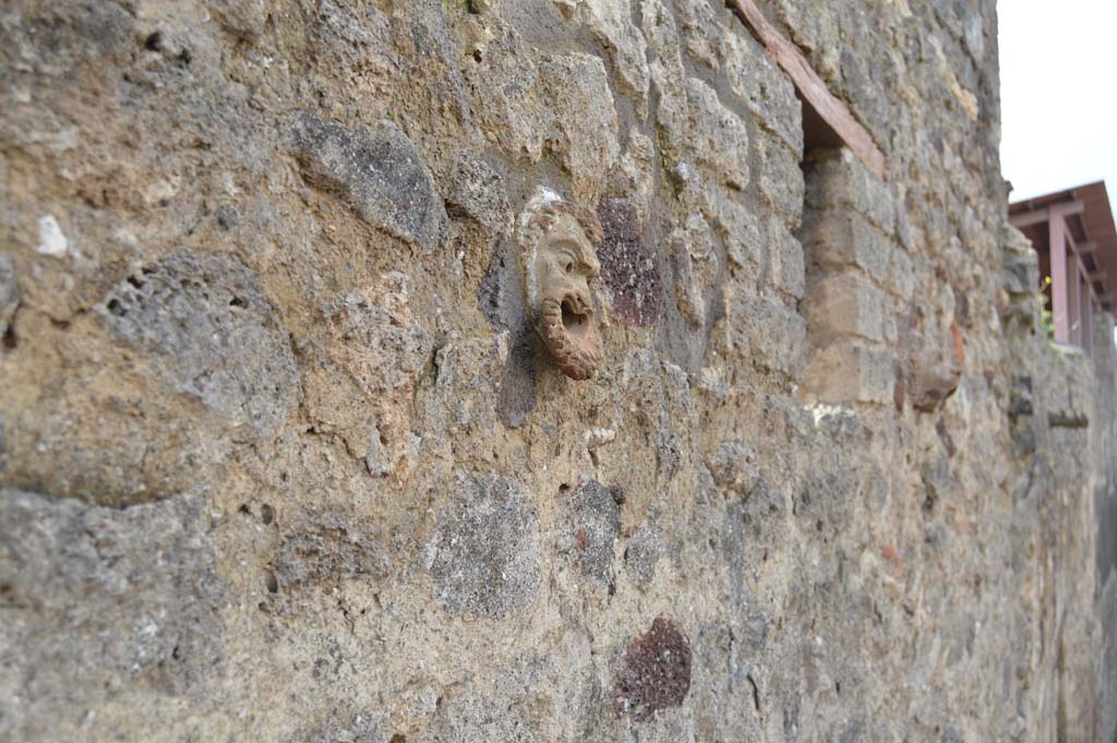 Vicolo del Centenario, west side, Pompeii. March 2018. Looking north along upper wall of IX.5.14-16, with detail of terracotta mask. 
Foto Taylor Lauritsen, ERC Grant 681269 DÉCOR.

