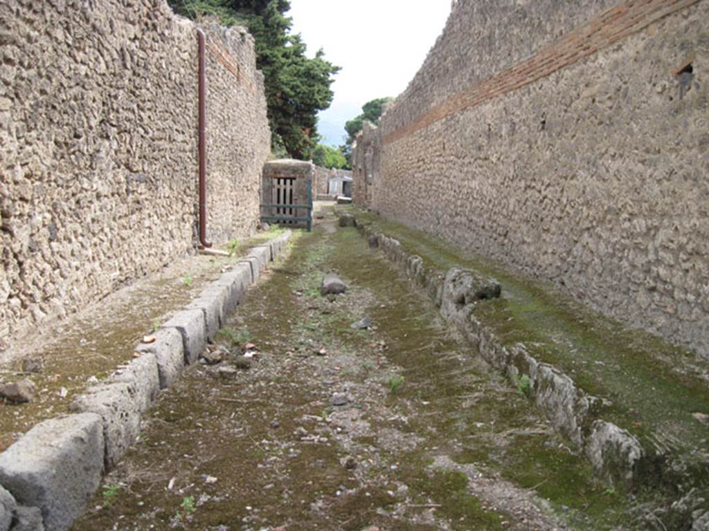 Pompeii. September 2010. Looking south along Vicolo del Citarista, between I.10 and side wall of I.3.24. Photo courtesy of Drew Baker.