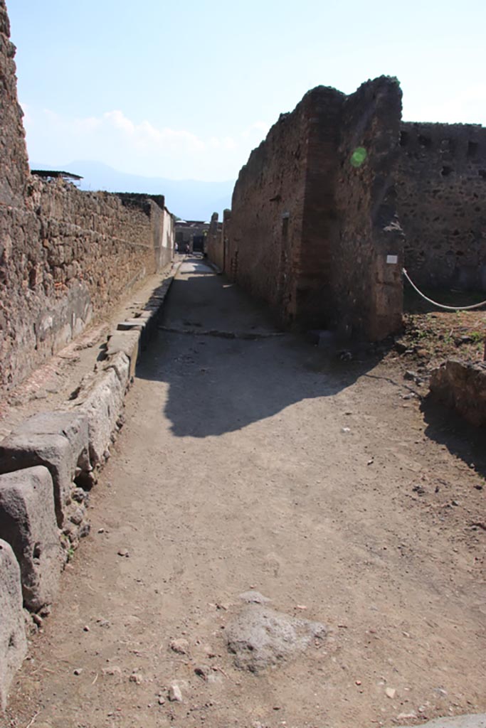 Vicolo del Fauno, Pompeii. October 2022. 
Looking south between VI.12 and VI.10, from crossroads with Vicolo di Mercurio. 
Photo courtesy of Klaus Heese.
