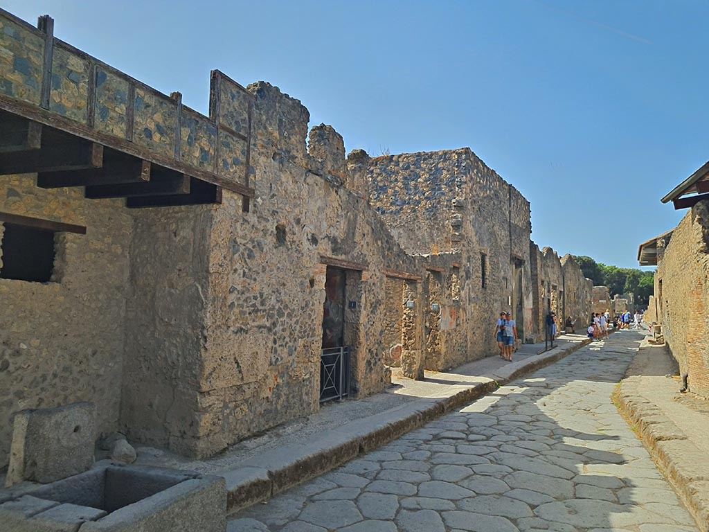 Vicolo del Menandro, Pompeii. September 2024.
Looking west between I.10 and I.6, from junction with Vicolo di Paquius Proculus. Photo courtesy of Giuseppe Ciaramella.