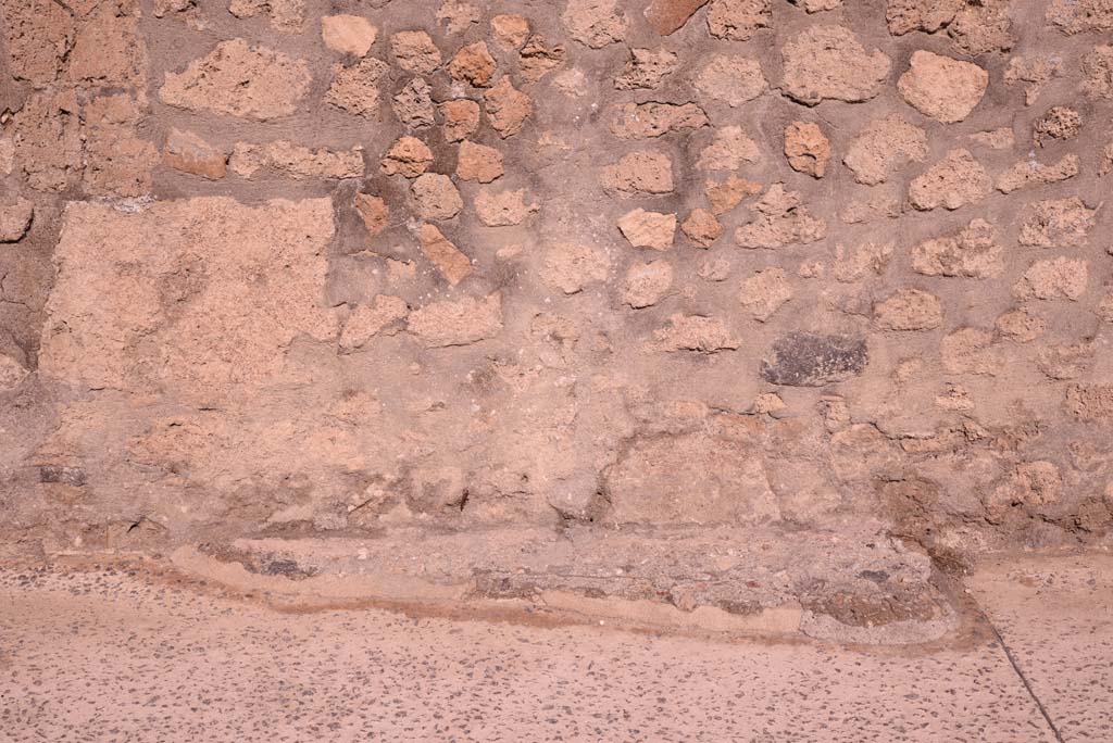 Vicolo del Menandro, north side, Pompeii. October 2019. Looking north to feature at base of wall. 
Foto Tobias Busen, ERC Grant 681269 DCOR.
