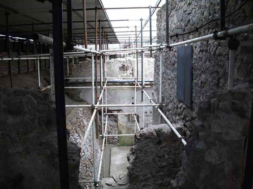 Vicolo di Giulio Polibio, Pompeii. May 2010. Excavation behind IX.13.1. Looking east from unnamed vicolo.
According to Cerulli Irelli,
“A work of excavation had been followed to isolate the humidity from the two splendid rear rooms of the said house (i.e. of IX.13.1/3 Julius Polybius), and the rustic quarters of a house has appeared to the north of this last house and presented a small kitchen with cupboard (repositorium) in a notable state of conservation, and a vast lararium picture with several elements on the rear wall of an uncovered/open room: this seemed to be evidence of plebeian art not inferior to the lararium picture found in the actual house of Julius Polybius.”
See Cerulli Irelli, G: Cronache Pompeiane, 2, (II), 1976, Notiziario, attività archeologica. (p.241).