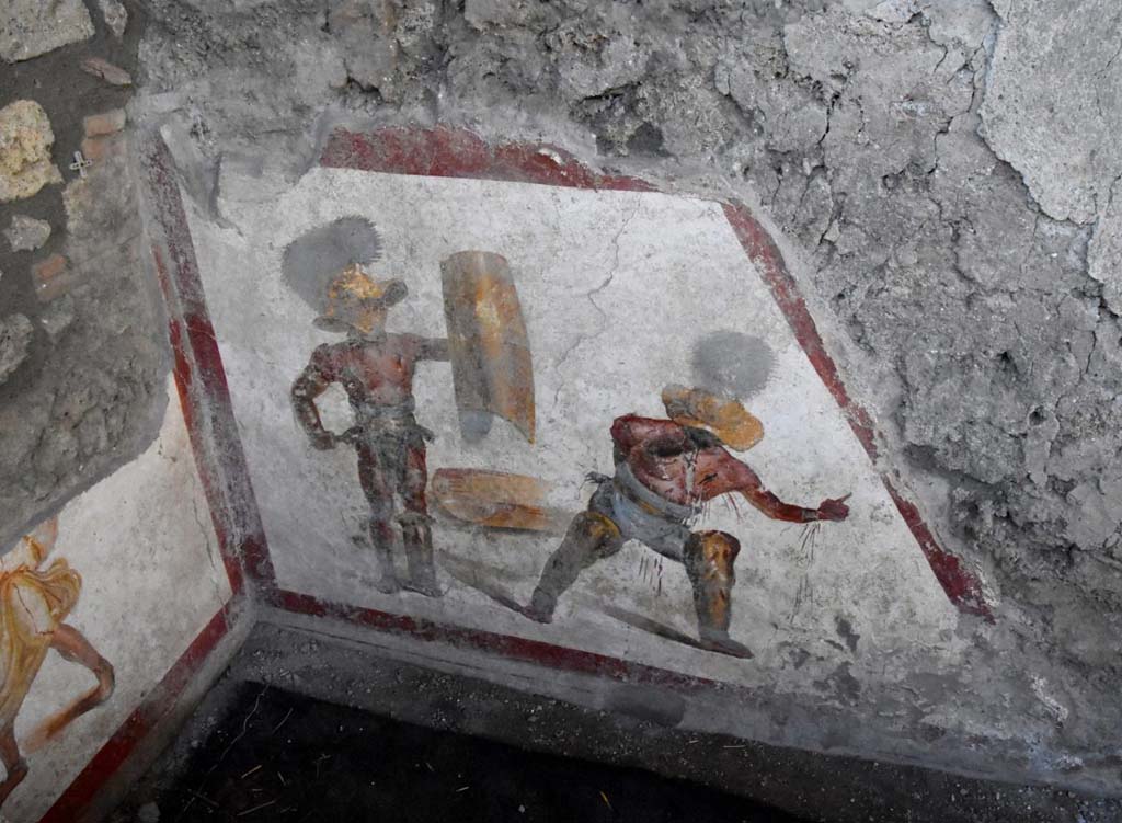 Two gladiators at the end of the fight, one wins the other succumbs.
The fresco of about 1.12 meters x 1.5 meters, found in a room behind the widening of the intersection of the Vicolo dei Balconi and the Vicolo delle Nozze D’Argento, has a trapezoidal shape, as it was located in the basement, perhaps of a shop. Above the painting we can see the imprint of the wooden staircase.
It is very likely that this place was frequented by gladiators, it is in the Regio V, not far from the caserma dei gladiatori from where, among other things, come the highest number of graffiti inscriptions related to their world. In this gladiatorial fresco of a Murmillo and a Thracian, of particular interest is the extremely realistic representation of the wounds, such as that on the wrist and chest of the succumbing gladiator, which let out the blood that also bathes the legs. We don't know what the final outcome of this fight was. You could die or have grace. In this case there is a singular gesture that the wounded Thracian makes with the hand, perhaps, to plead for salvation; it is the gesture of ad locutia, usually made by the emperor or the general to grant grace.
Due gladiatori al termine del combattimento, l’uno vince l’altro soccombe
L’affresco di circa 1,12 mt x 1,5mt, rinvenuto in un ambiente alle spalle dello slargo di incrocio tra il Vicolo dei Balconi e il vicolo delle Nozze d’Argento, ha forma trapezoidale, in quanto era collocato nel sottoscala, forse di una bottega. Si intravede al di sopra della pittura, l’impronta della scala lignea.
E’ molto probabile che questo luogo fosse frequentato da gladiatori. Siamo nella Regio V, non lontani dalla caserma dei gladiatori da dove, tra l’altro, provengono il numero più alto di iscrizioni graffite riferite a questo mondo. In questo affresco di un Mirmillone e un Trace, di particolare interesse è la rappresentazione estremamente realistica delle ferite, come quella al polso e al petto del gladiatore soccombente, che lascia fuoriuscire il sangue e bagna i gambali. Non sappiamo quale fosse l’esito finale di questo combattimento. Si poteva morire o avere la grazia. In questo caso c’è un gesto singolare che il trace ferito fa con la mano, forse, per implorare salvezza; è il gesto di ad locutia, abitualmente fatto dall’imperatore o dal generale per concedere la grazia.
http://pompeiisites.org/comunicati/laffresco-dei-gladiatori-combattenti-nuova-scoperta-nella-regio-v/