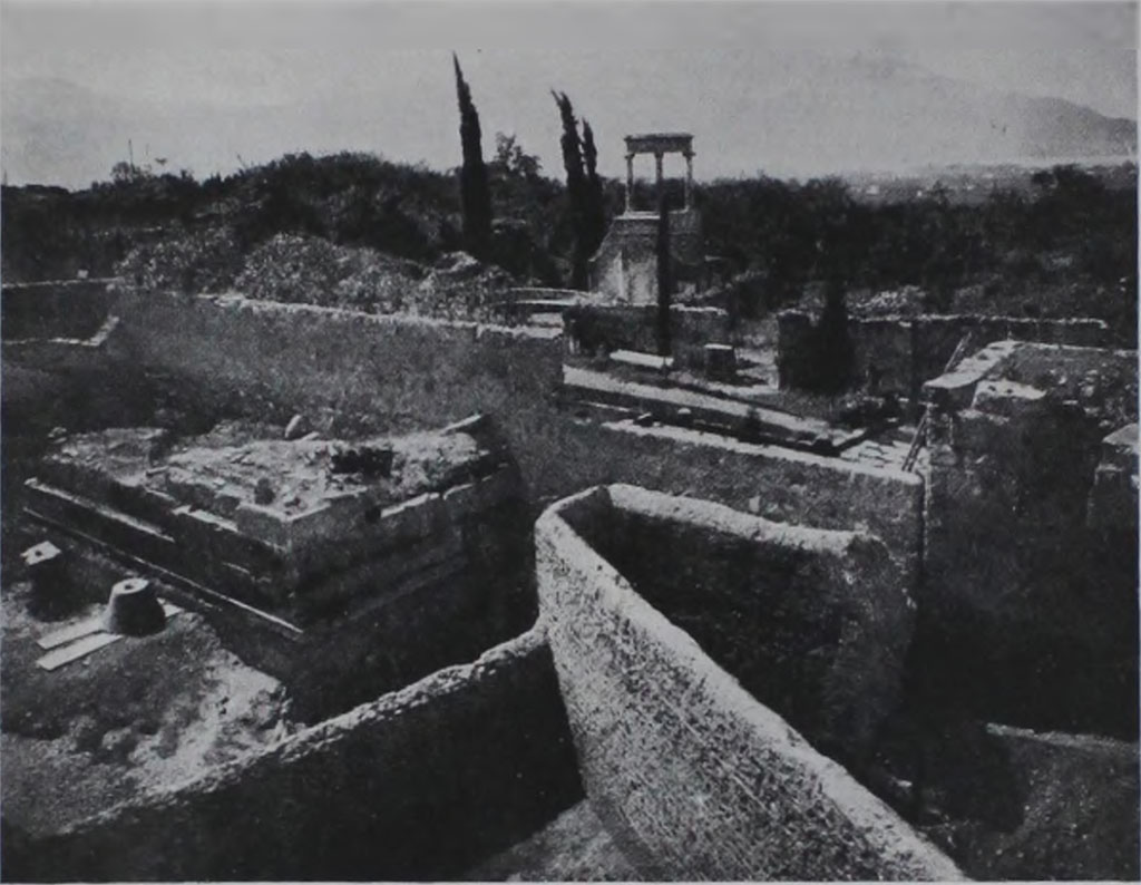 HGE04 Pompeii. 1933-5. View of rear of tomb during excavations showing also the cone found by Maiuri.
According to Kockel in 1933/35, A. Maiuri excavated the entire area between the city wall and the Villa delle Colonne a mosaico, completely exposing North 4 as well.
To the north of the base he found a cone and a Corinthian capital to match.
See Kockel V., 1983. Die Grabbauten vor dem Herkulaner Tor in Pompeji. Mainz: von Zabern, p. 122.
See Notizie degli Scavi di Antichità, 1943, p. 301, fig. 17.