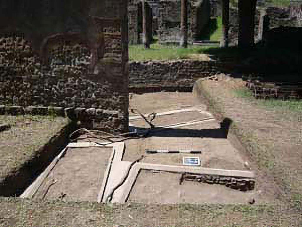 HGE15A Pompeii. 2009 re-excavation of three Samnite graves by the Via Consolare Project.
The location of three graves is clustered around the base of the wall.
The two graves in the metal frames are also visible on the other side of the gap in the wall.
Excavations in 2009 were carried out by the Via Consolare Project and their report commented that:
Extensive modern deposits were removed from the area, revealing three heavily reconstructed, irregularly-aligned inhumation cist-graves.
It is likely that these constructions are the result of the excavations of A. Maiuri in the 1930-40’s and were a component of his preparations of the Villa for general display that included replanting the viridarium and running water to the nymphaeum.
Photo courtesy of the Via Consolare Project. See http://www.viaconsolareproject.org/research2009.html