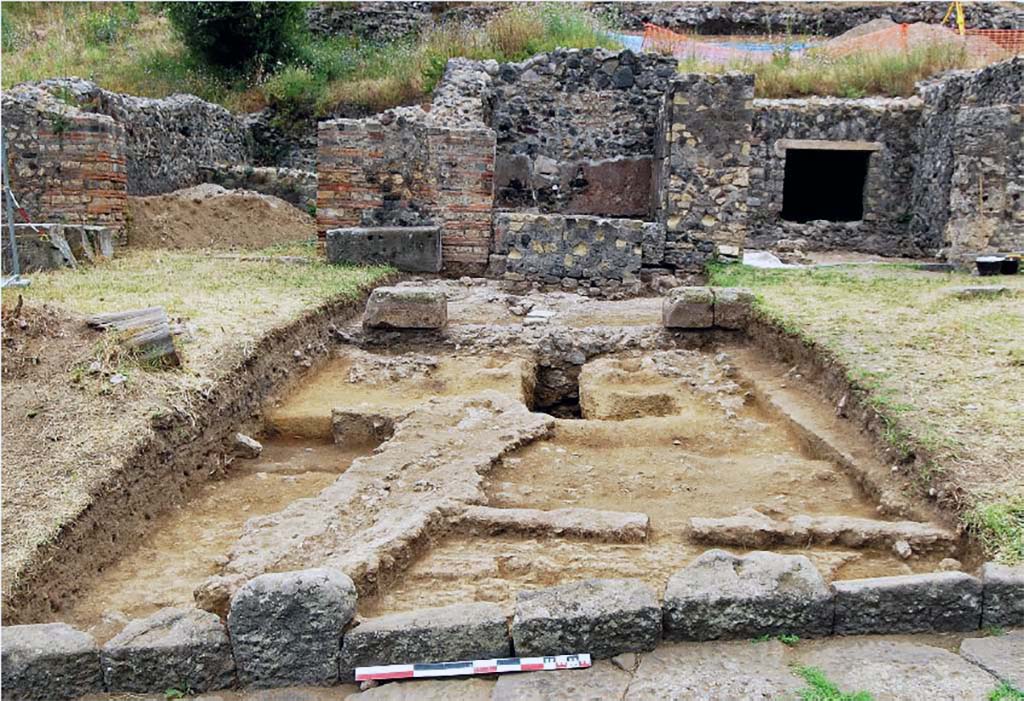 HGE20a Pompeii. Portico in front of the fountain. The ancient pit and more recent levels intercepted in the area.
In front of the fountain work was still in progress at the time of the eruption. The excavations were able to intercept a deep pit which, starting from the base of the fountain and passing under the foundations of the portico, ended at an angle at the end of the base of the fountain and passing under the foundations of the portico, ended at an angle to the south. south. The axis of the pit is centred between the two pillars of the arcade (Fig. 16). The pit pierces geological levels to a depth of about 2.40 m; it was filled with lapilli which was not reworked during the excavation.
Photo: B. Lemaire-EFR
Portique devant la fontaine HGE20a. La fosse antique et les niveaux plus récentes interceptés dans le secteur.
Devant la fontaine, des travaux étaient en revanche en cours au moment de l’éruption. Les fouilles ont en effet pu intercepter une fosse profonde qui, partant de la base de la fontaine et passant sous les fondations du portique, se terminait en équerre au sud. L’axe de la fosse est centré entre les deux piliers de l’arcade (fig. 16). La fosse perce les niveaux géologiques jusqu’à environ 2,40 m de profondeur ; elle était remplie de lapilli non remaniés lors de la fouille.
Cliché : B. Lemaire-EFR
See Pompéi, Porta Ercolano : organisation, gestion et transformations d’une zone suburbaine : Campagne 2016, fig. 16. CEFR 1676